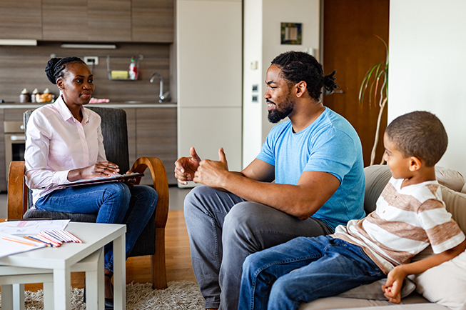 Social worker talking to a father and his son