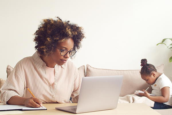 woman on computer with child in the background