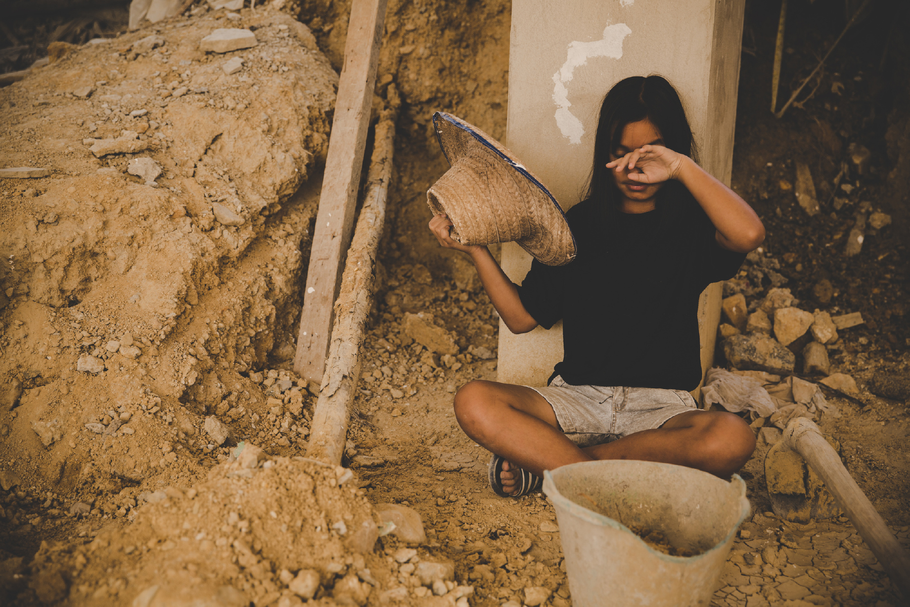 little girl sitting on a pile of sand